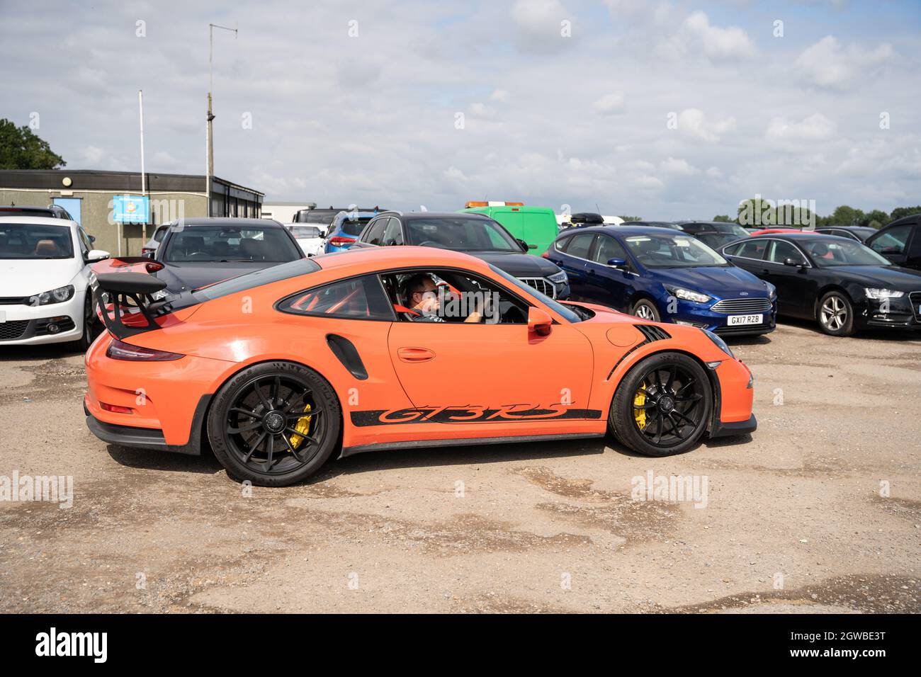 Orange Porsche GT3 RS Sportwagen auf dem Parkplatz für Motorsport-Events Stockfoto