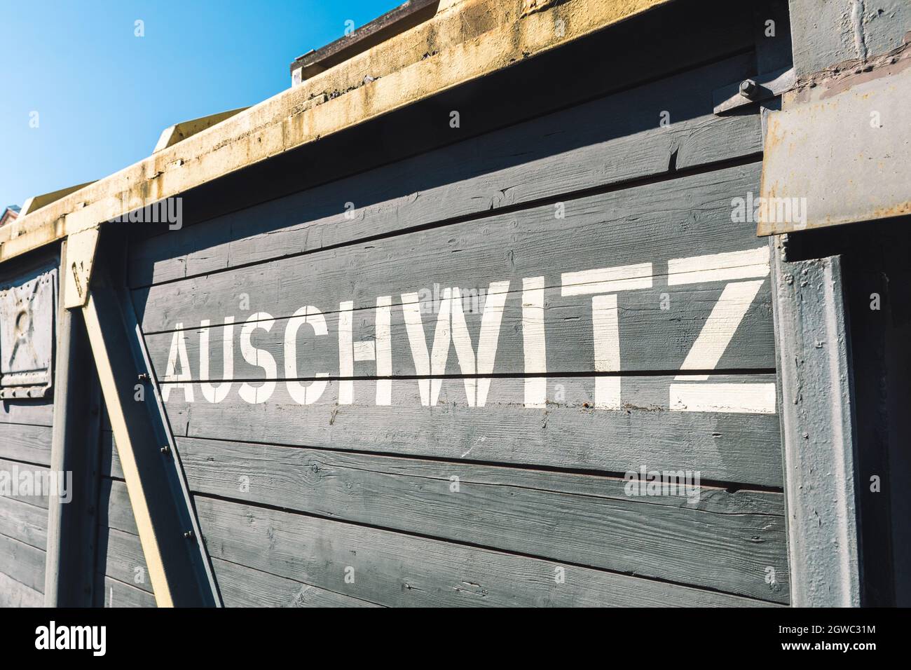 Auschwitz in weißen Großbuchstaben geschrieben auf einem Holzwagen eines alten ursprünglichen Güterzugs auf der Entladeplattform von Birkenau-Auschwitz Stockfoto