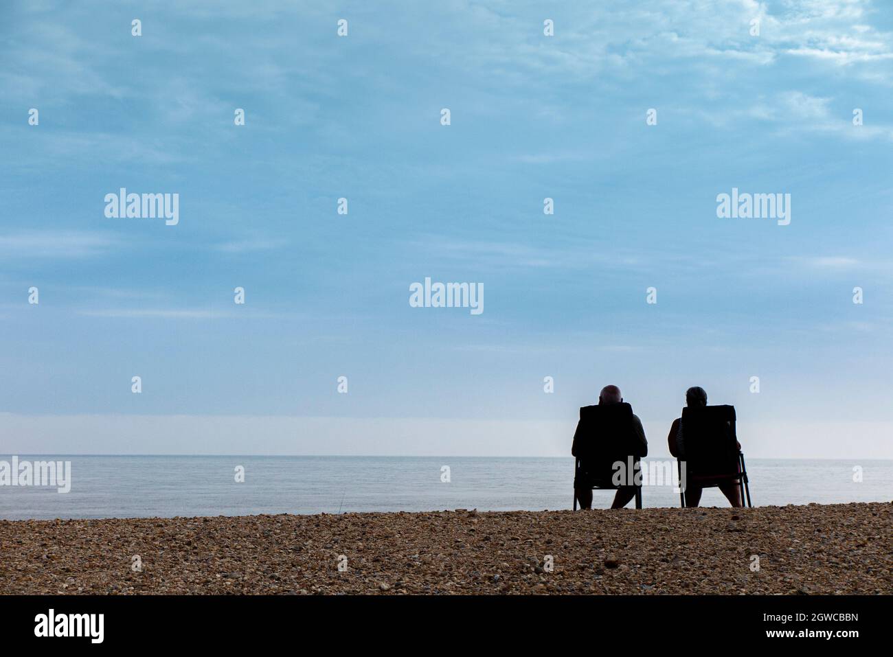 Zwei Freunde sitzen und genießen den Blick auf den Strand Stockfoto