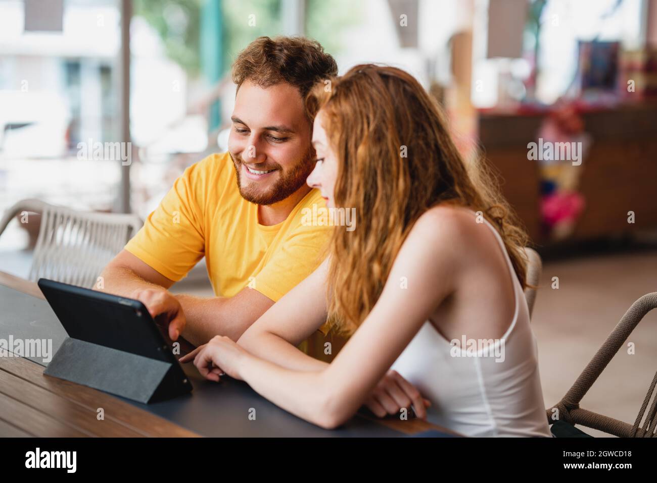 Eine Gruppe von Freunden oder Kollegen, die im Café sitzen und auf ein Tablet schauen. Hochwertige Fotos Stockfoto