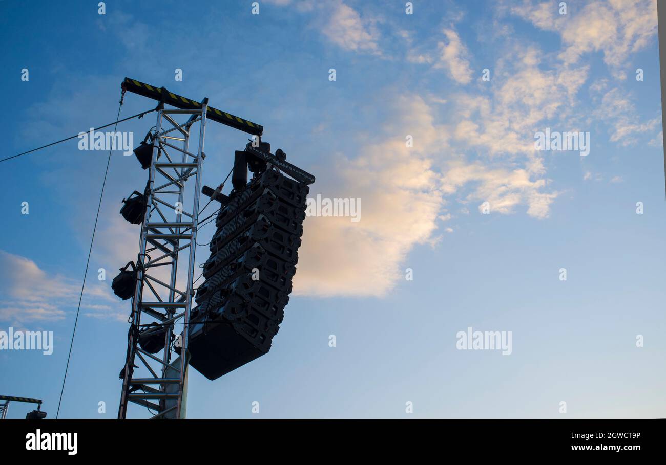 Line-Array-Lautsprechersystem, das bei Tageslicht an der Stange hängt. Sonnenuntergang blauer Himmel Hintergrund Stockfoto