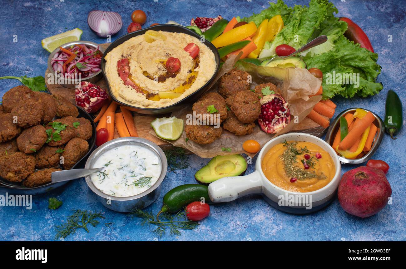 Mediterrane Speisen mit Hummus, Falafel, geröstetem Pfefferdip, Joghurtsauce, Kruditen Stockfoto