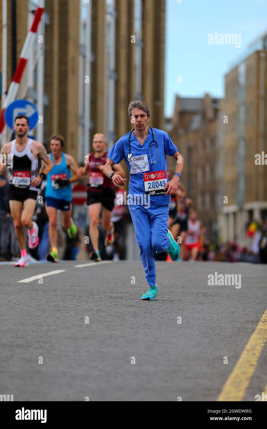London, Großbritannien. London, Großbritannien. 3. Oktober 2021; London, England: The Virgin Money 2021 London Marathon: "Dr. CHRIS" ("28049") in medizinischem Outfit, als das erste ausgefallene Kleid zwischen Mile 14 und 15 über die enge Street Swing Bridge im Limehouse Basin läuft. Kredit: Action Plus Sports Images/Alamy Live News Gutschrift: Action Plus Sports Images/Alamy Live News Stockfoto
