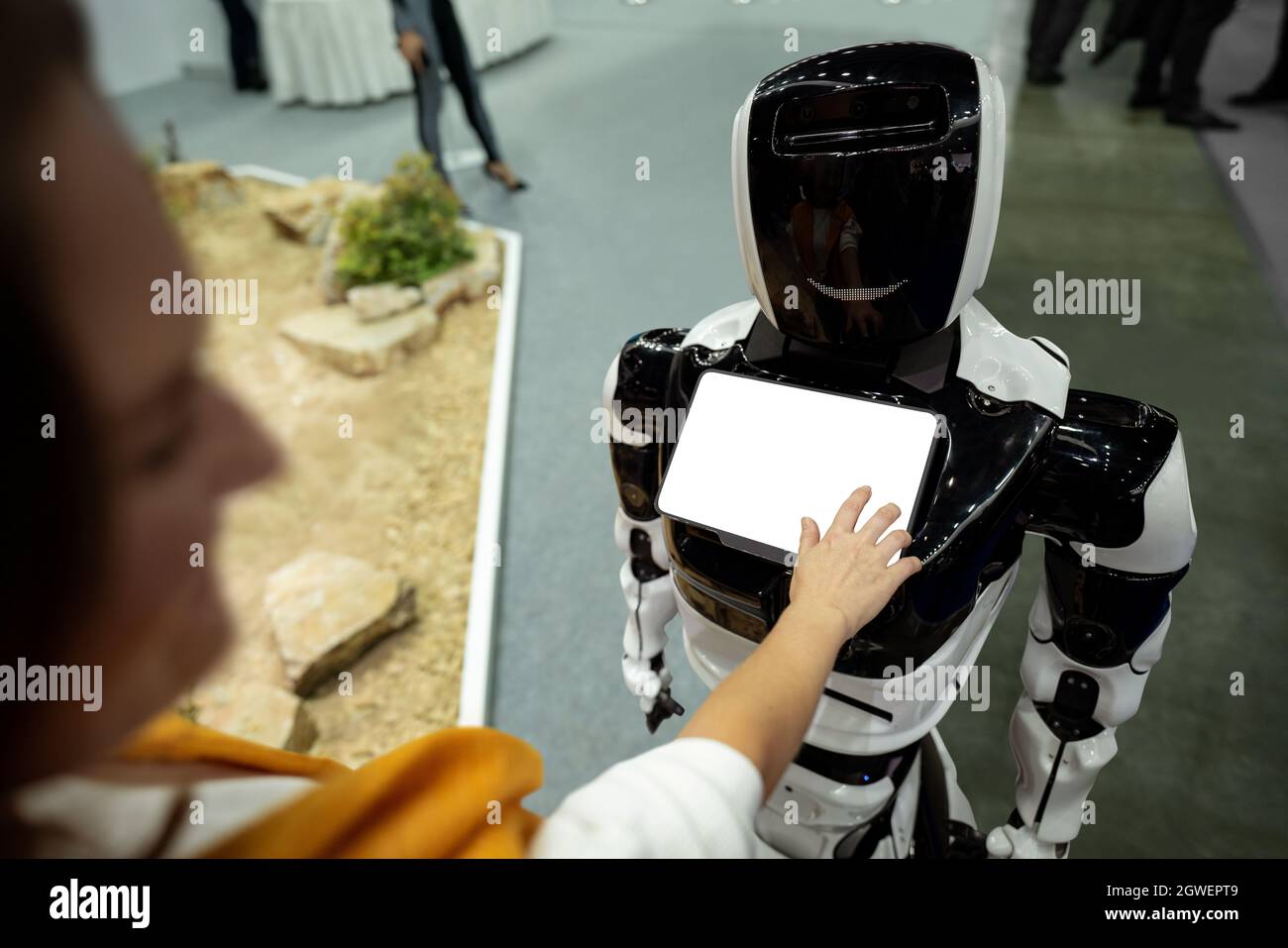Frau, die einen Touchscreen eines Roboters an der Rezeption verwendet Stockfoto
