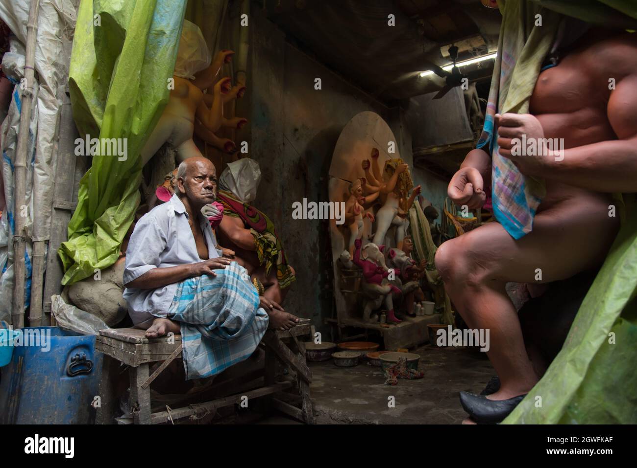 Als Durga Puja um die Ecke ist, ist ein besorgter alter Mann in seiner Werkstatt mit unvollständigen Idolen. Stockfoto