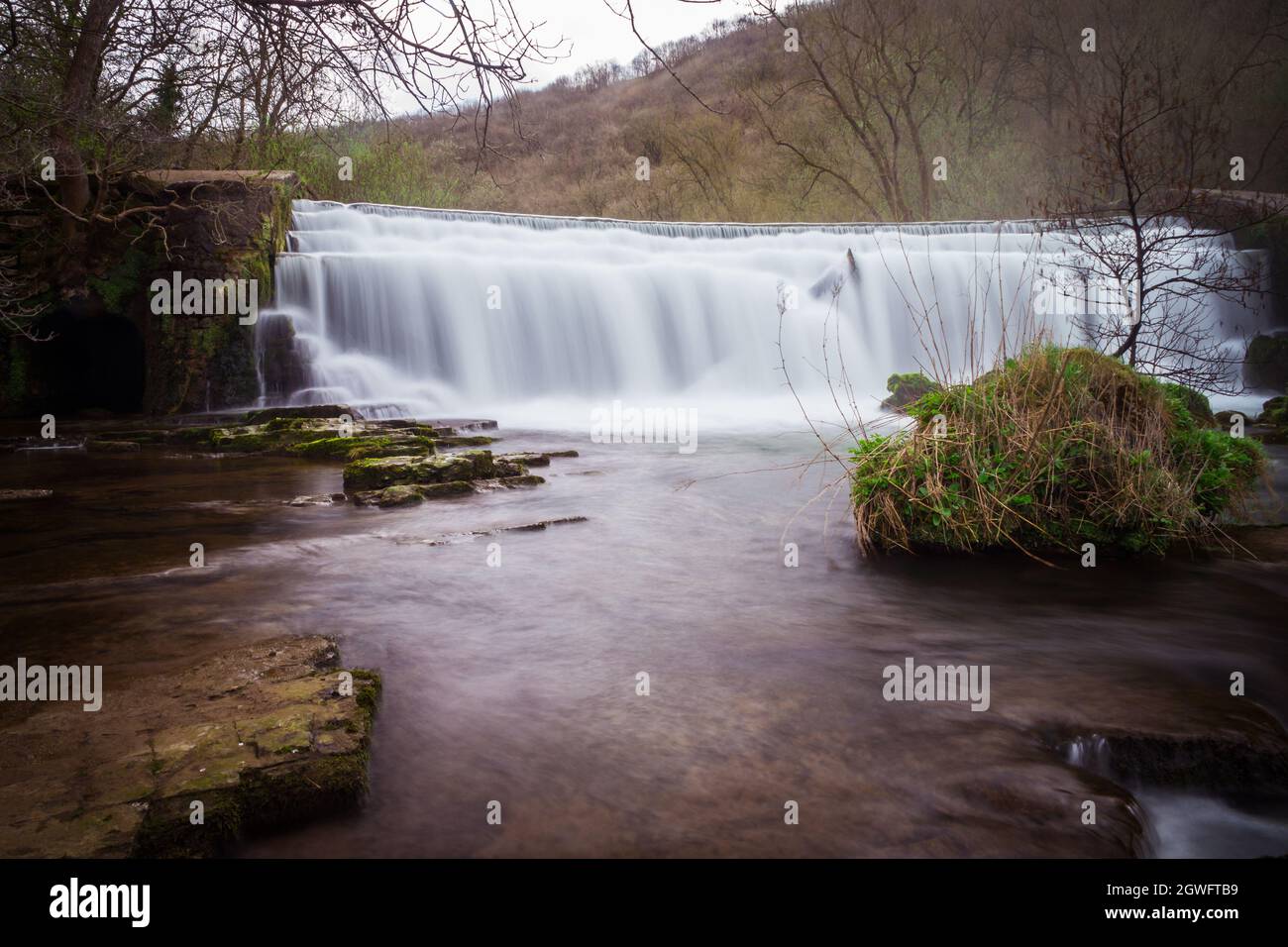 Langzeitbelichtung des Monsal Dale Weir Wasserfalls und des Flusses Wye auf dem Monsal Trail im Peak District Stockfoto