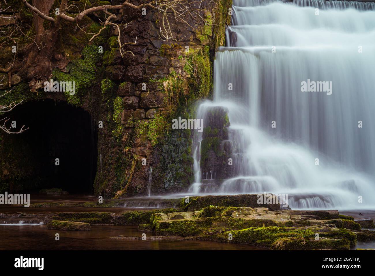 Langzeitbelichtung des Monsal Dale Weir Wasserfalls und des Flusses Wye auf dem Monsal Trail im Peak District Stockfoto