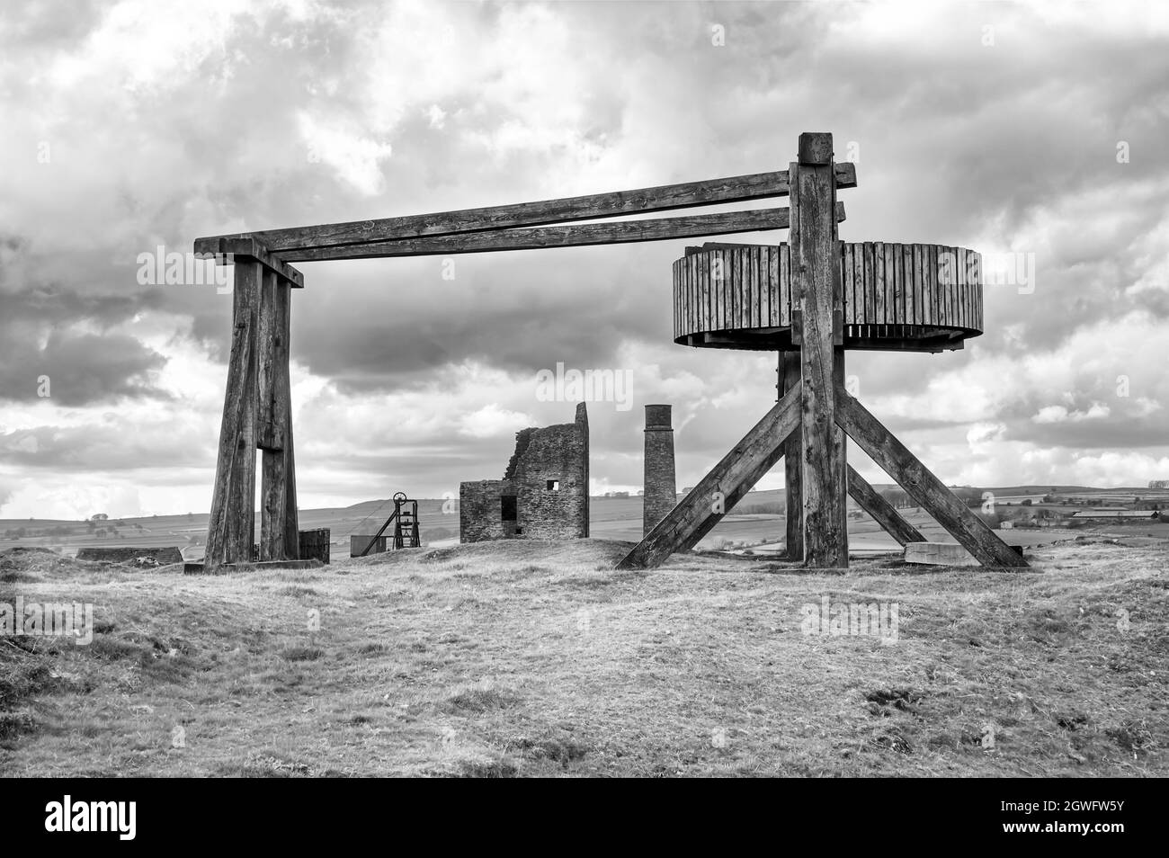 Der nachgebaute hölzerne Pferdegin mit entferntem Maschinenhaus und Kamin in der Magpie Mine, Sheldon, einer erhaltenen Bleimine im Peak District National Park Stockfoto