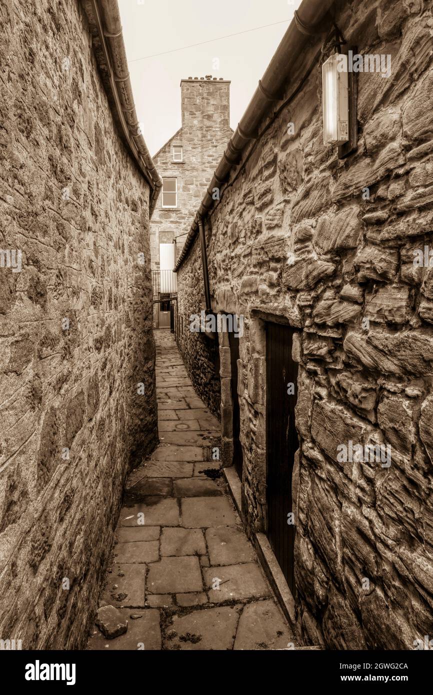 Sepiafarbene Fotografie einer Gasse in Lerwick im alten Stil. Das ist Greigs Closing. Original fotografiert 2021. Stockfoto
