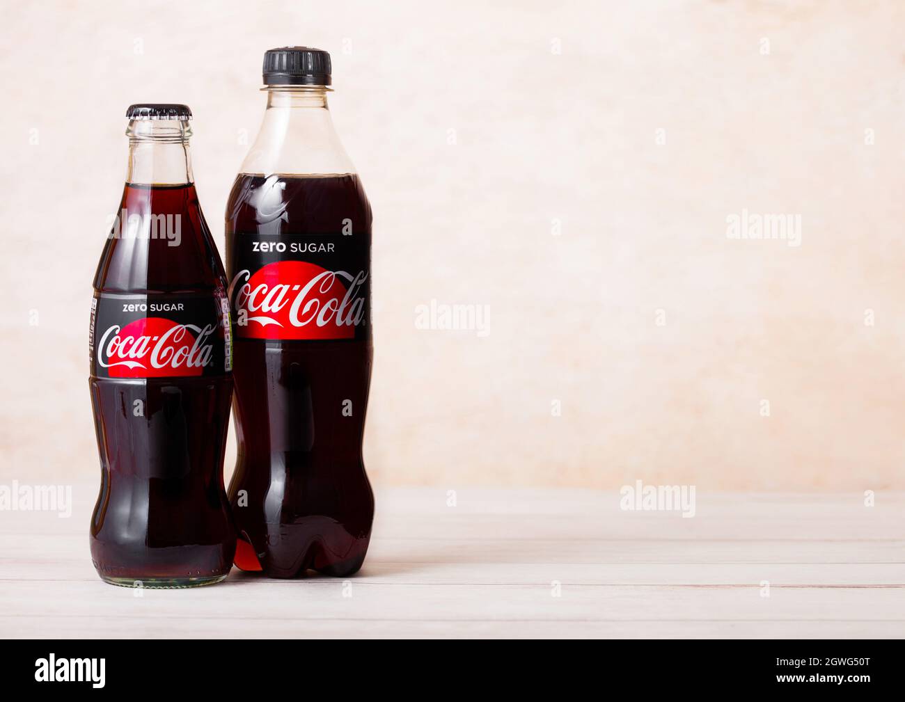 LONDON, Großbritannien - 03. AUGUST 2018: Glas- und Plastikflasche Zero Sugar Coca Cola Softdrink auf Holz. Das beliebteste Getränk der Welt. Stockfoto