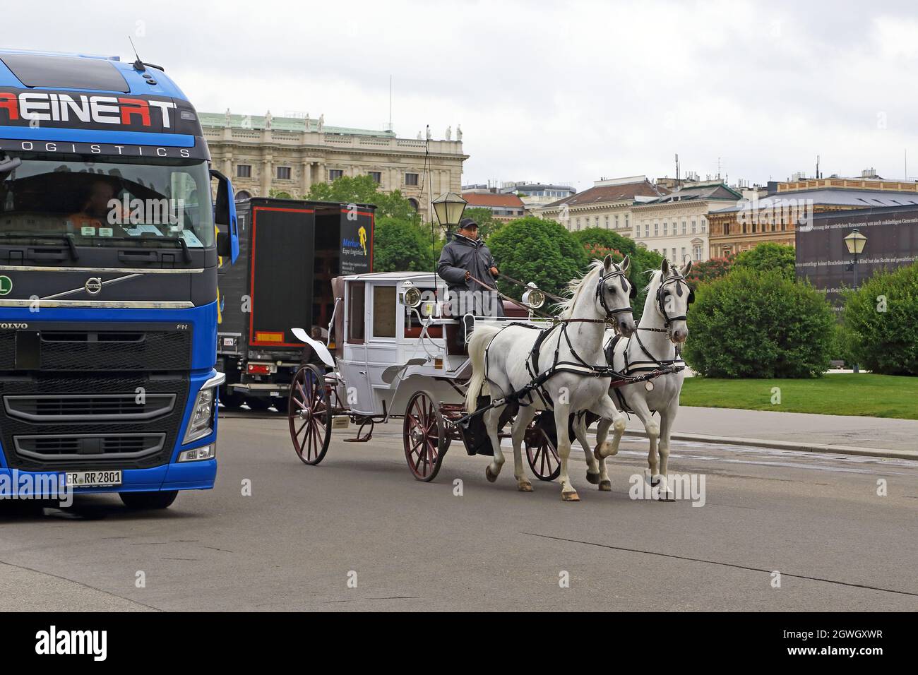 WIEN, ÖSTERREICH - 15. MAI 2019: Eine alte Pferdekutsche überholt moderne Fahrzeuge auf den Straßen der historischen Stadt Stockfoto WIEN, ÖSTERREICH - 15. MAI 2019: Eine alte Pferdekutsche überholt moderne Fahrzeuge auf den Straßen der historischen Stadt Stockfoto