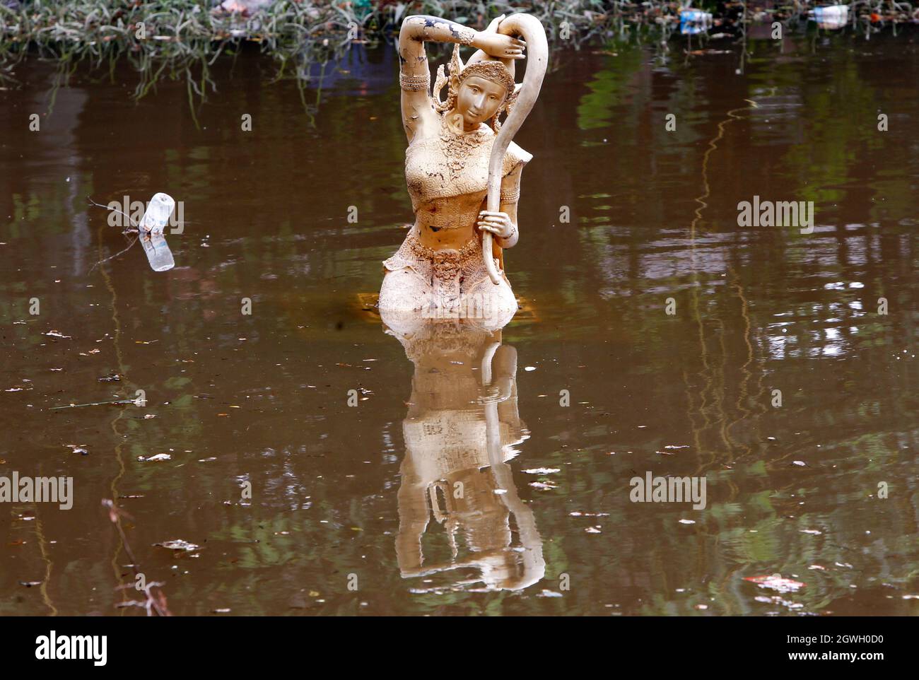 Eine Phra Mae Thorani Statue wird in einem überfluteten Tempel gesehen, als Wasser aus dem Chao Phraya Fluss in der Provinz Pathum Thani fließt. Der Einfluss des Sturms von Dianmu, der das Land trifft, hat die Befürchtungen verstärkt, dass sich die Mega-Überschwemmungen, die das Flussbecken des Chao Phraya vor 10 Jahren heimgesucht haben, wiederholen werden. Diese Katastrophe verursachte Schäden von über 100 Milliarden Baht. Obwohl viele Wasserexperten die Befürchtungen zerstreuen und sagen, dass die Wassermenge im Flussbecken in diesem Jahr im Vergleich zur großen Überschwemmung im Jahr 2011 deutlich geringer ist, gibt es dennoch viele Ähnlichkeiten. Stockfoto