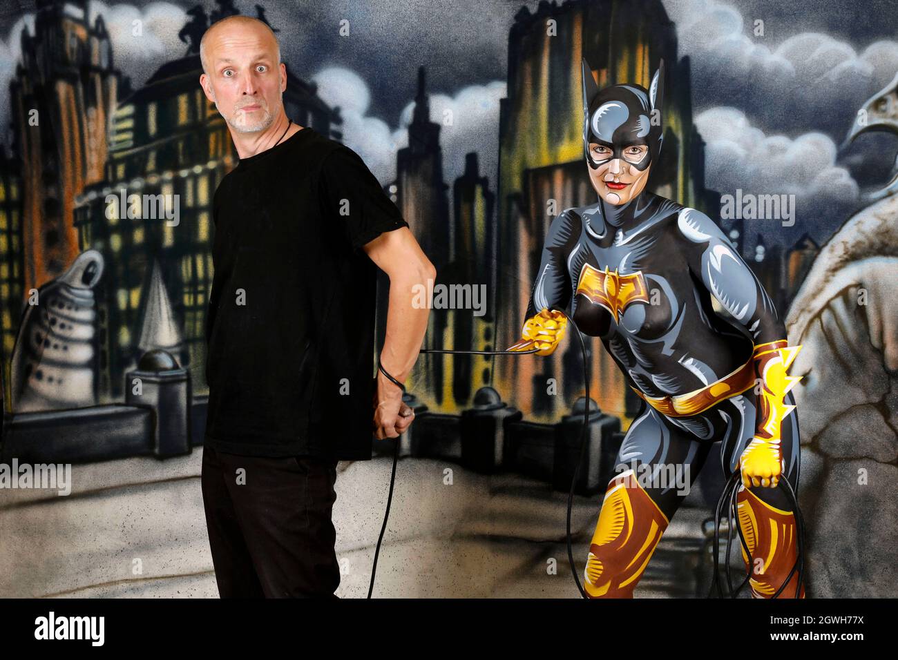 GEEK ART - Bodypainting und Transformaking: Enrico Lein während eines Batgirl-Comic-Fotoshootings mit Janina in einem besprühten Comic-Setting von Enrico Lein im Studio Düsterwald in Hameln am 27. September 2021 - Ein Projekt der Fotografin Tschiponnique Skupin und des Bodypainters Enrico Lein Stockfoto