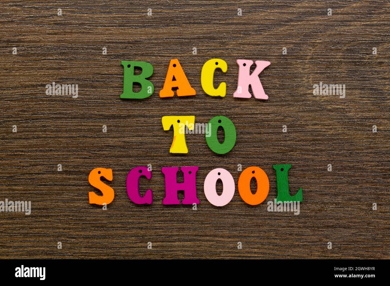 Inschrift der Worte des Slogans Back to School in mehrfarbigen Buchstaben auf einem schönen Hintergrund. Bunte Buchstaben des englischen Alphabets Stockfoto