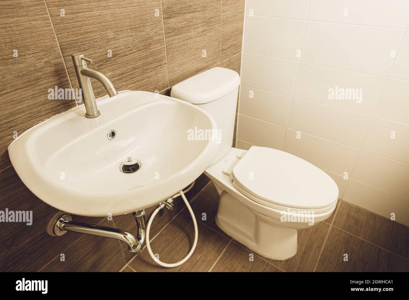 Handwaschbecken und Toilettenschüssel im heimischen Badezimmer. Stockfoto