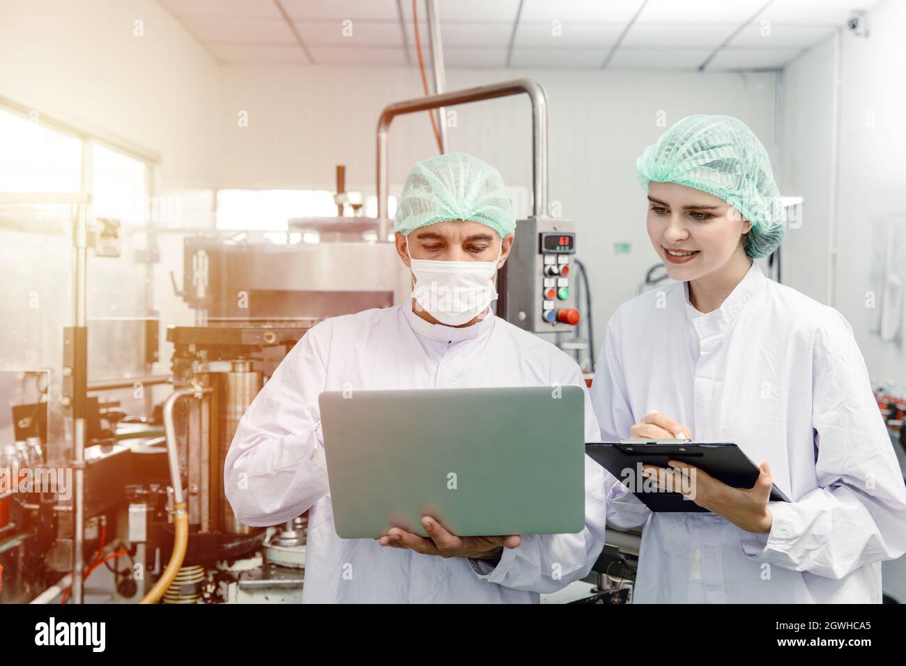 Mitarbeiter in der Fabrik überprüfen die Qualitätskontrolle in der Fabrik oder in der Industrie sammeln Forschungsteam Daten in der Getränkefabrik mit Laptop. Stockfoto