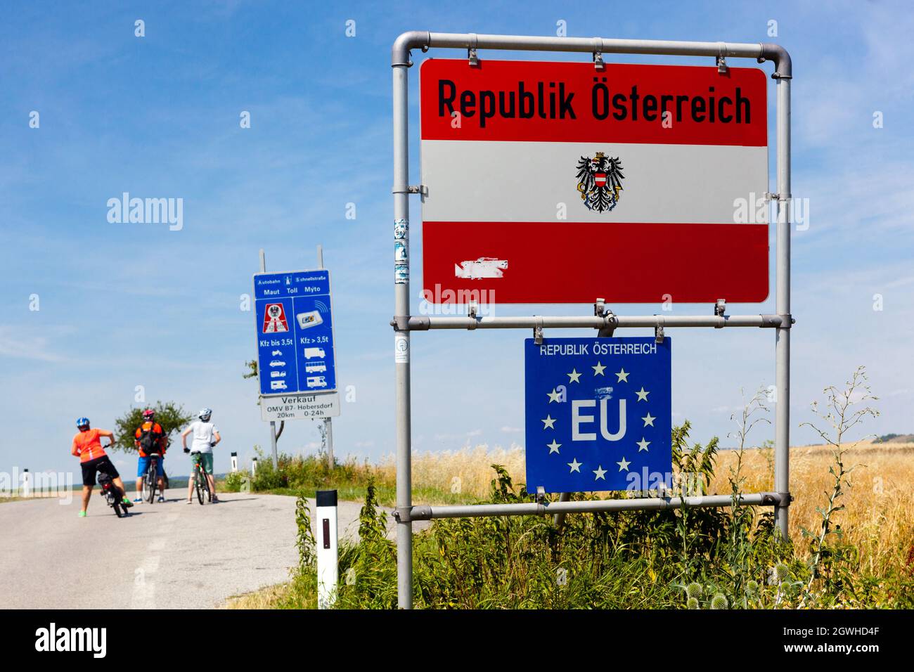 Menschen auf Fahrrädern Grenzen, Grenzübertritt nach Österreich, EU-Zeichen, Sommerurlaub Stockfoto