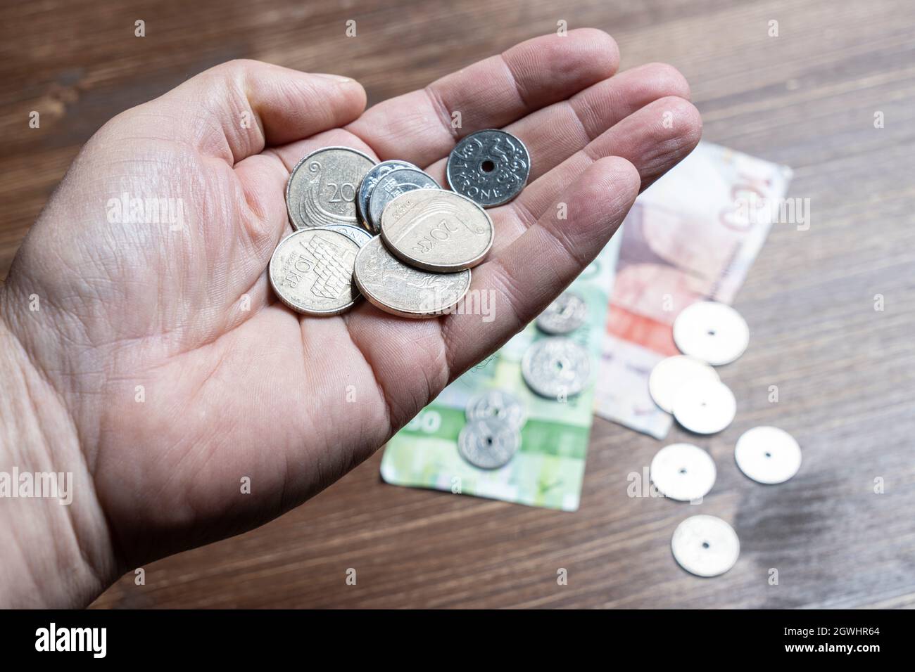 Oslo, Norwegen. September 2021. Einige norwegische Kronen-Scheine und Münzen in der Hand Stockfoto