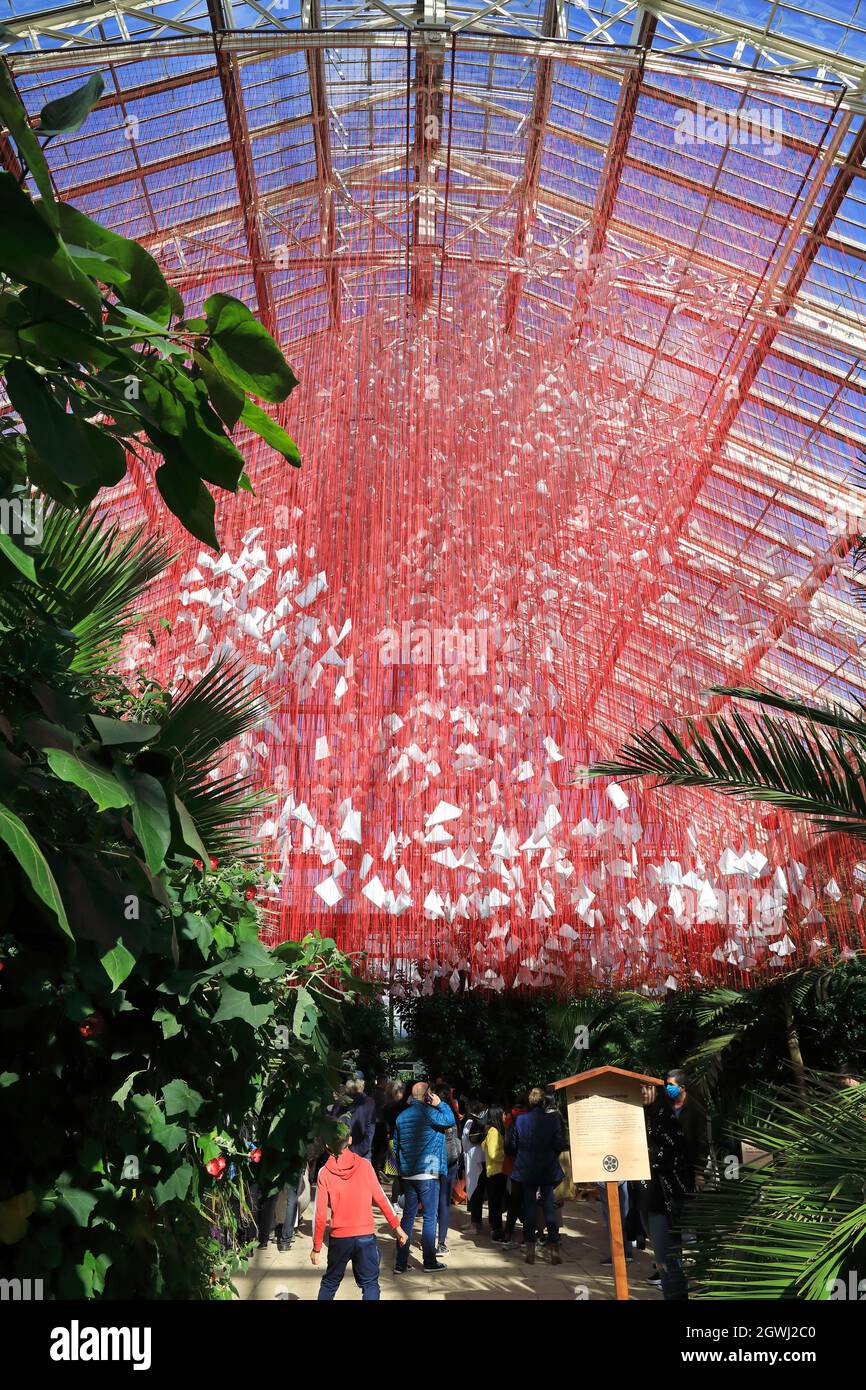 One Thousand Springs, eine komplizierte Konstruktion aus 5000 Haikus, die in einem Netz aus roten Fäden aufgehängt wurden, von dem japanischen Künstler Chiharu Shiota im gemäßigten Haus, dem Herzstück des Japan Festivals, in Kew Gardens, London, Großbritannien Stockfoto