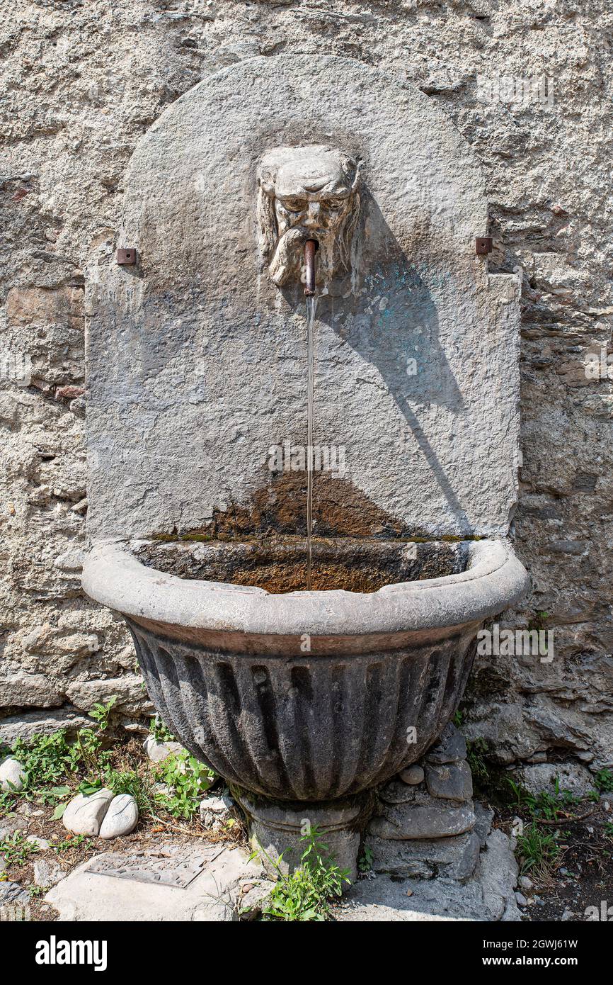 Uralter Steinbrunnen mit dem Kopf eines bärtigen Mannes Stockfoto