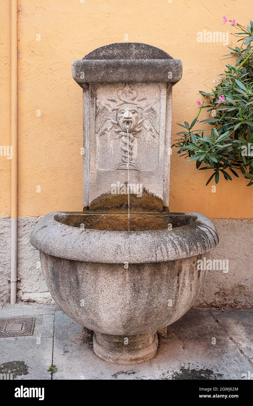 Nahaufnahme eines antiken Brunnens mit einer Caduceus-Skulptur Stockfoto