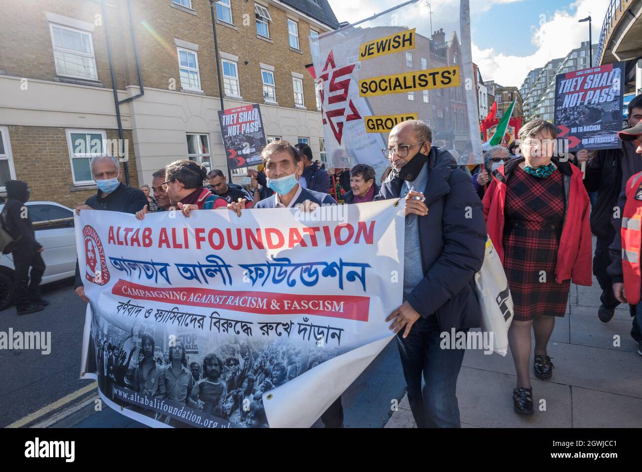 London, Großbritannien. Oktober 2021. Das Banner der Altab Ali Foundation auf dem marsch zum 85. Jahrestag der Schlacht an der Cable Street erinnert an den Akt der Einheit gegen die faschistische Bedrohung, als die jüdische und irische Gemeinde im Osten Londons und ihre Verbündeten die Straßen blockierten, um Oswald Mosley und seine britische Union zu verhindern Der Faschisten, die durchmarschieren. Sie marschierten von der Dock Street entlang der Cable Street zu einer Kundgebung neben dem Wandgemälde in St. George's Gardens unter dem Vorsitz des jüdischen Historikers David Rosenberg und der lokalen bengalischen Aktivistin Julie Begum. Peter Marshall/Alamy Live News Stockfoto