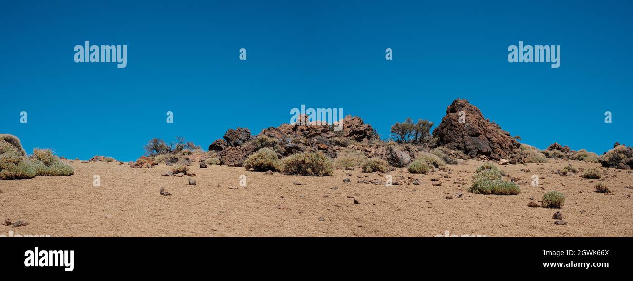 Steine und Sand, felsige Wüstenlandschaft mit blauem Himmel Hintergrund. Stockfoto
