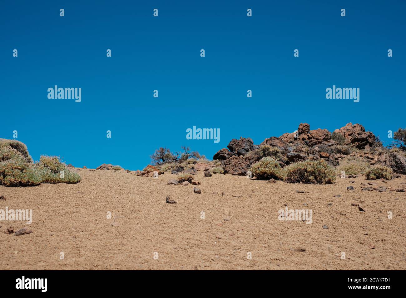 Steine und Sand, felsige Wüstenlandschaft mit blauem Himmel Hintergrund. Stockfoto