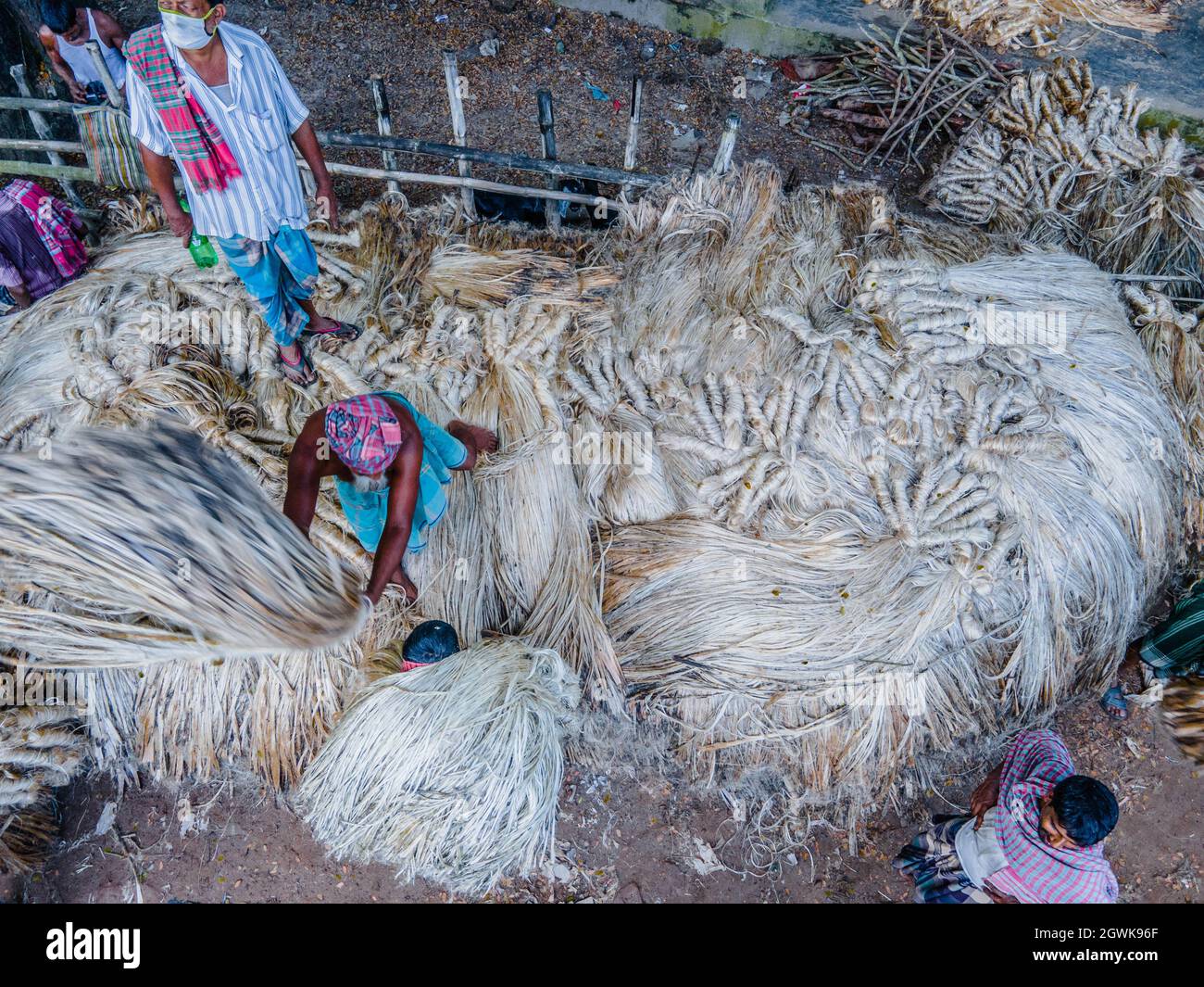 Non Exclusive: DHAKA, BANGLADESCH - 3. OKTOBER 2021: Jutearbeiter verarbeiten Jutepakete während der Juteernte auf einem Großhandelsmarkt in Zentral-Bangl Stockfoto