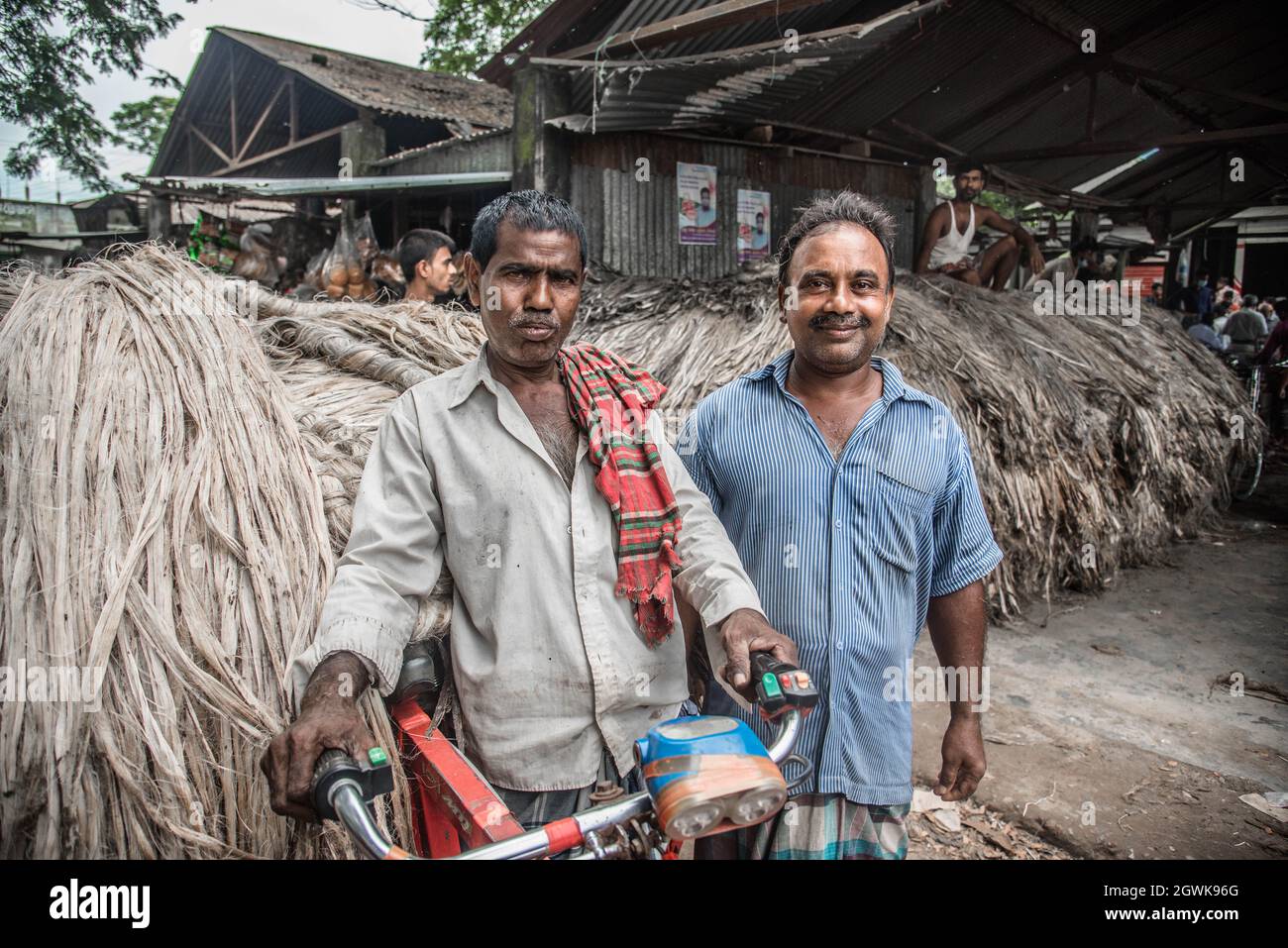 Non Exclusive: DHAKA, BANGLADESCH - 3. OKTOBER 2021: Jutearbeiter verarbeiten Jutepakete während der Juteernte auf einem Großhandelsmarkt in Zentral-Bangl Stockfoto