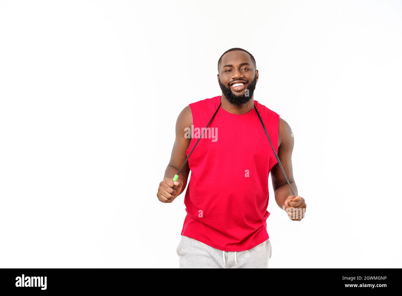 Afrikanische Fitness-Modell mit Seilspringen vor grauem Hintergrund. Schöner muskulöser Mann posiert mit Seilspringen. Stockfoto