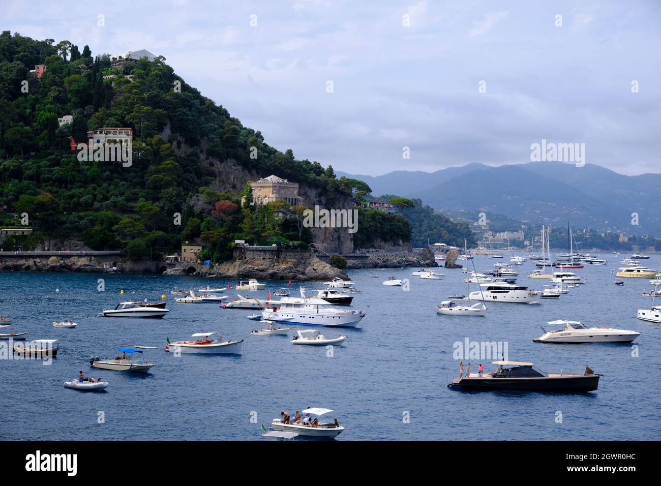 Natürlicher Blick auf eine Festung und die bunten Häuser von Portofino mit einem natürlichen Laubbogen und die Boote im mittelmeer Stockfoto