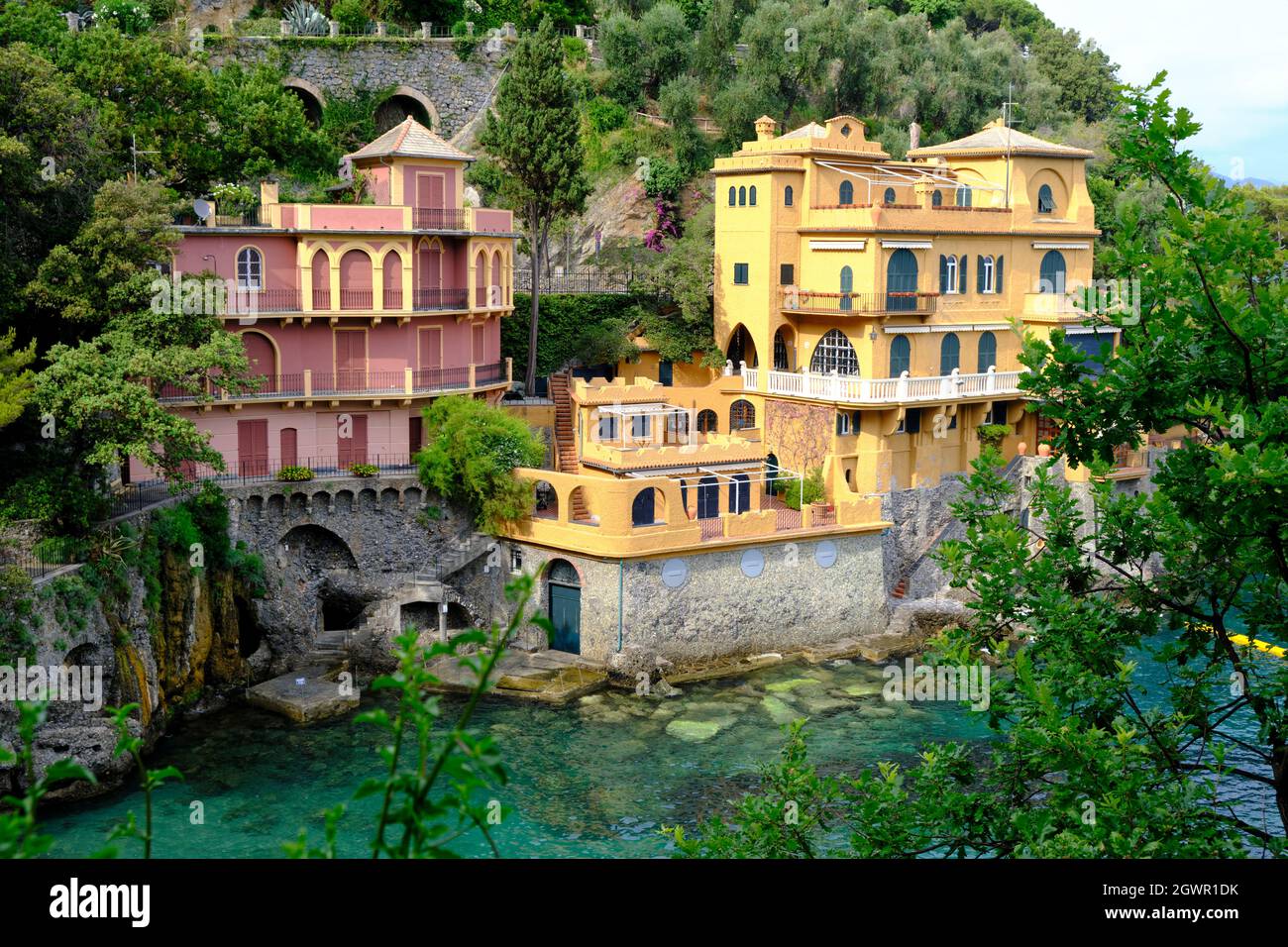 Bunte Häuser von Portofino mit einem natürlichen Laubbogen im mittelmeer mit den Booten Stockfoto