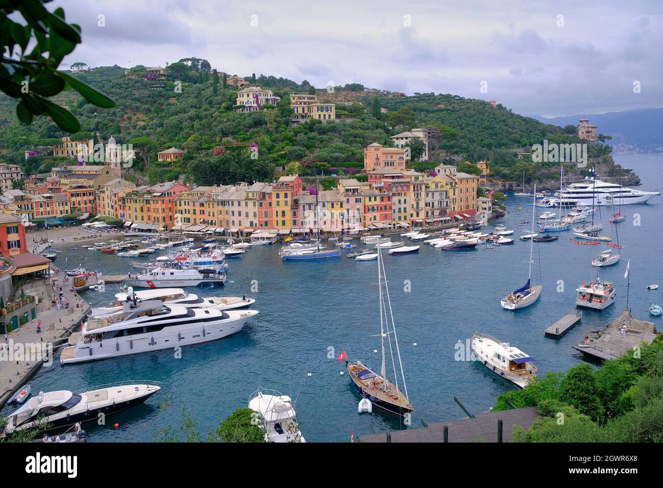 Bunte Häuser von Portofino mit einem natürlichen Laubbogen im mittelmeer mit den Booten Stockfoto