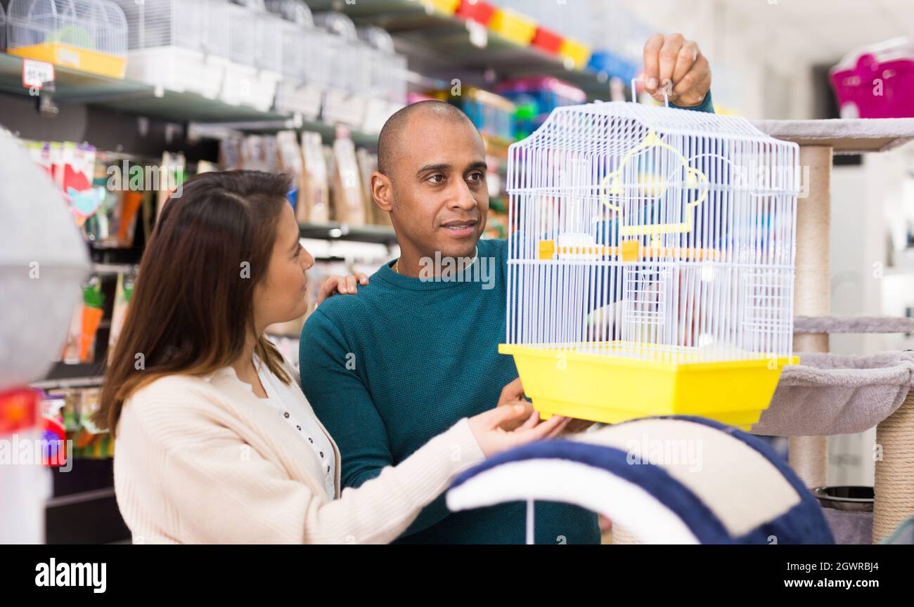 Das Familienpaar wählt den Vogelkäfig im Laden Stockfoto