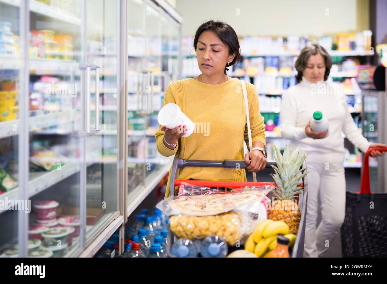 Weibliche Shopper wählt Milchprodukte im Supermarkt Stockfoto