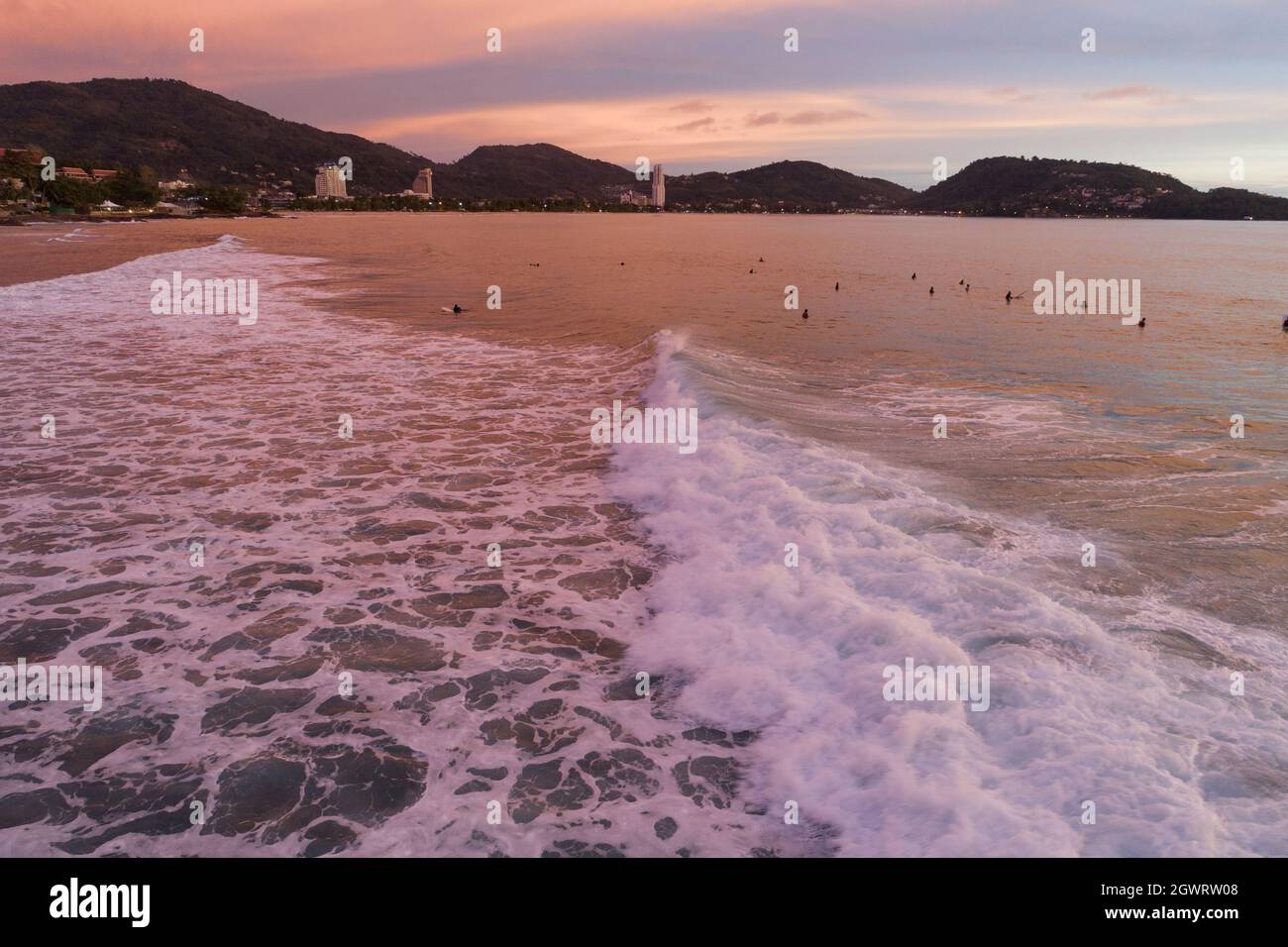 Atemberaubende Luftaufnahmen Wellen brechen auf tropischem Meer Surfer mit Surfbrettern Luftdrohnenansicht der Meereswellen mit wunderschönem Sonnenuntergang oder Sonnenaufgangshimmel bei Phu Stockfoto