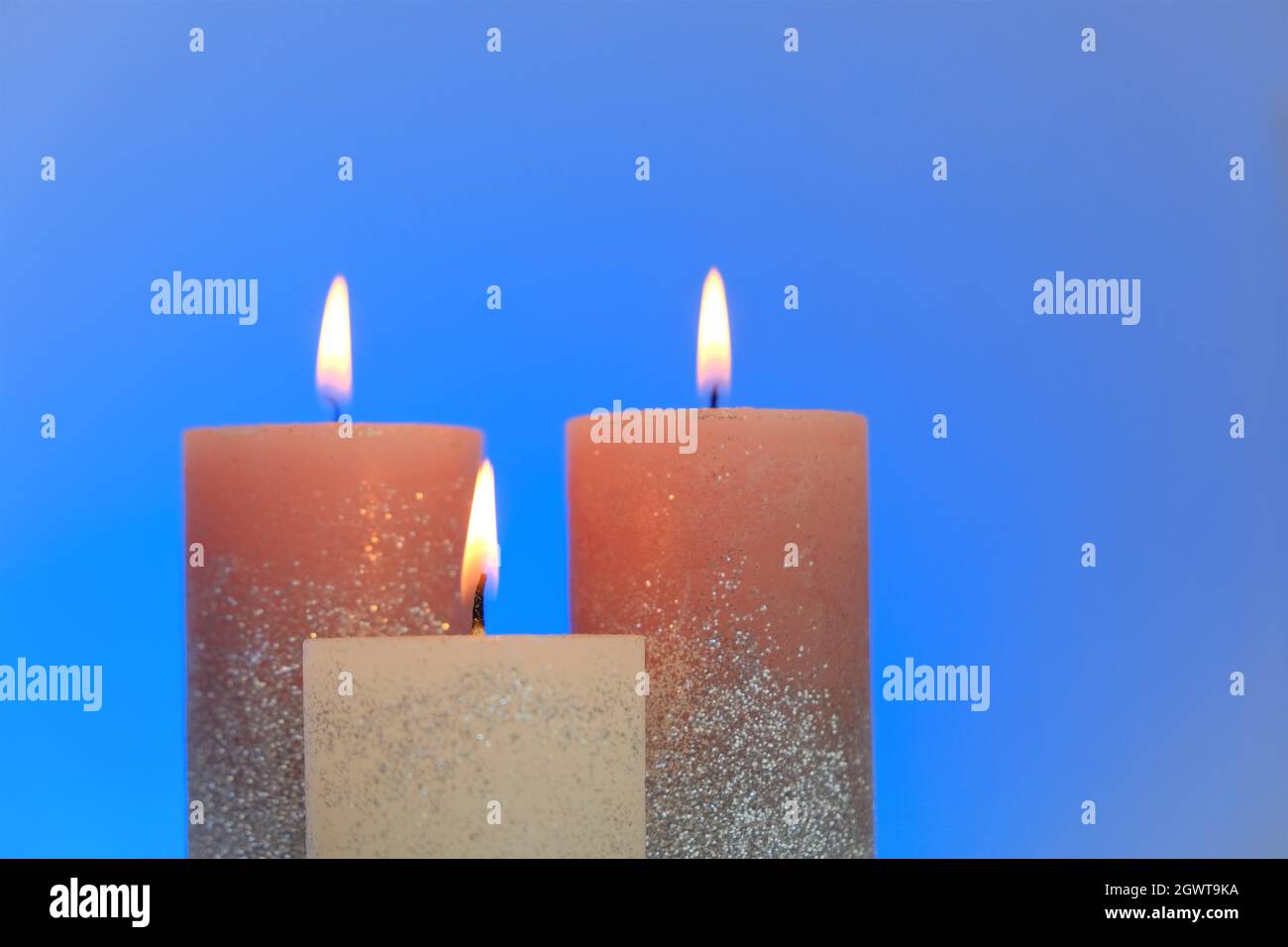 Kerzen Hintergrund. Glänzende Kerzen auf einem blauen Hintergrund.Dekorative Kerzen.Brennen schöne Kerzen.Religion und Kultur Stockfoto