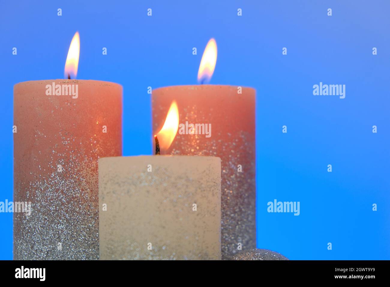 Kerzen Hintergrund. Glänzende Kerzen auf einem blauen Hintergrund.Dekorative Kerzen.Brennen schöne Kerzen Stockfoto