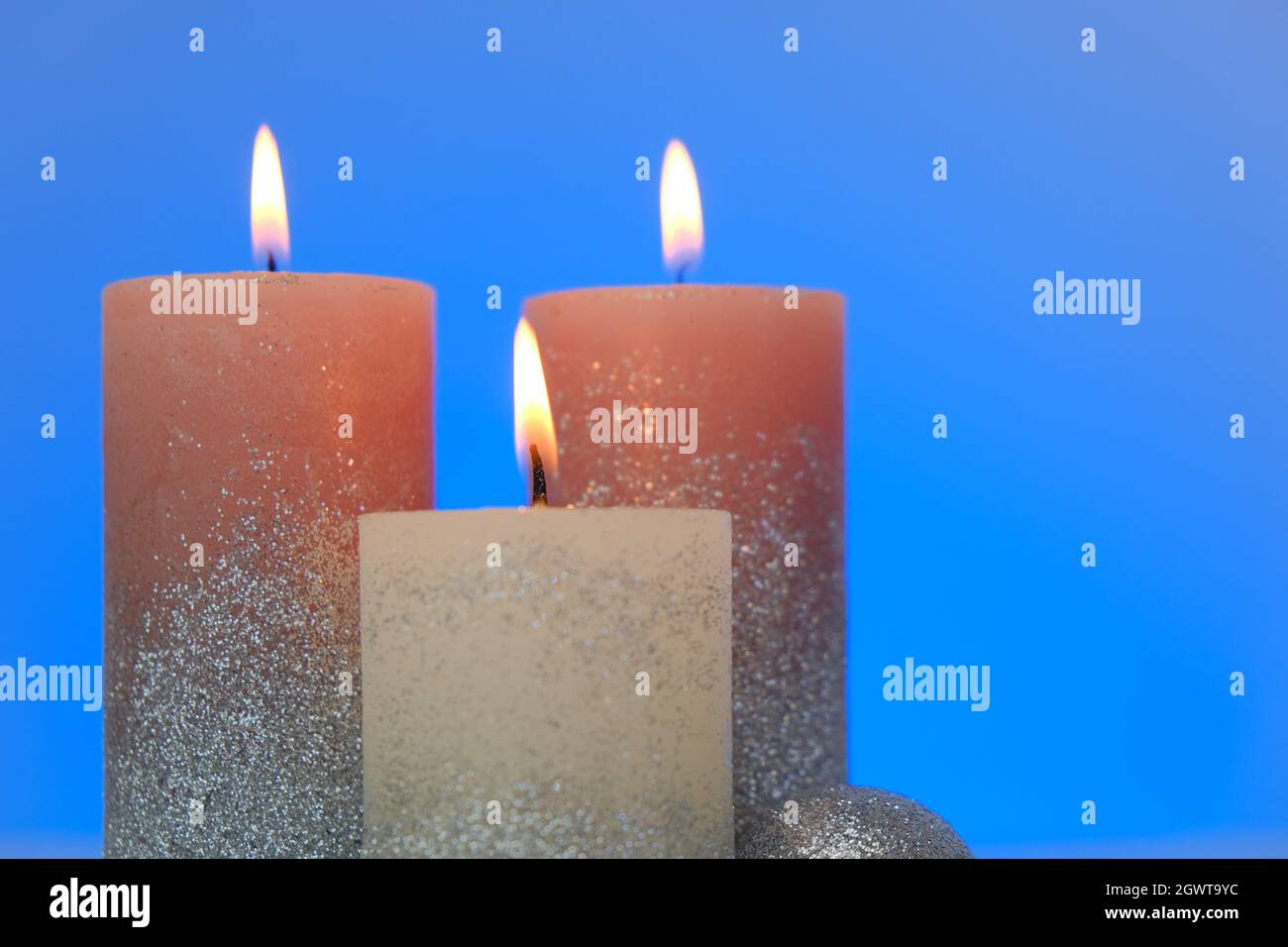 Kerzen Hintergrund. Glänzende Kerzen auf einem blauen Hintergrund.Brennen schöne Kerzen.Religion und Kultur Stockfoto