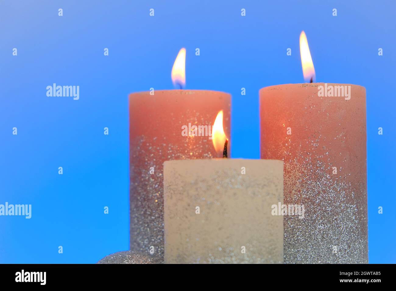 Kerzen Hintergrund. Glänzende Kerzen auf einem blauen Hintergrund.Dekorative Kerzen.brennende Kerzen.Religion und Kultur Stockfoto