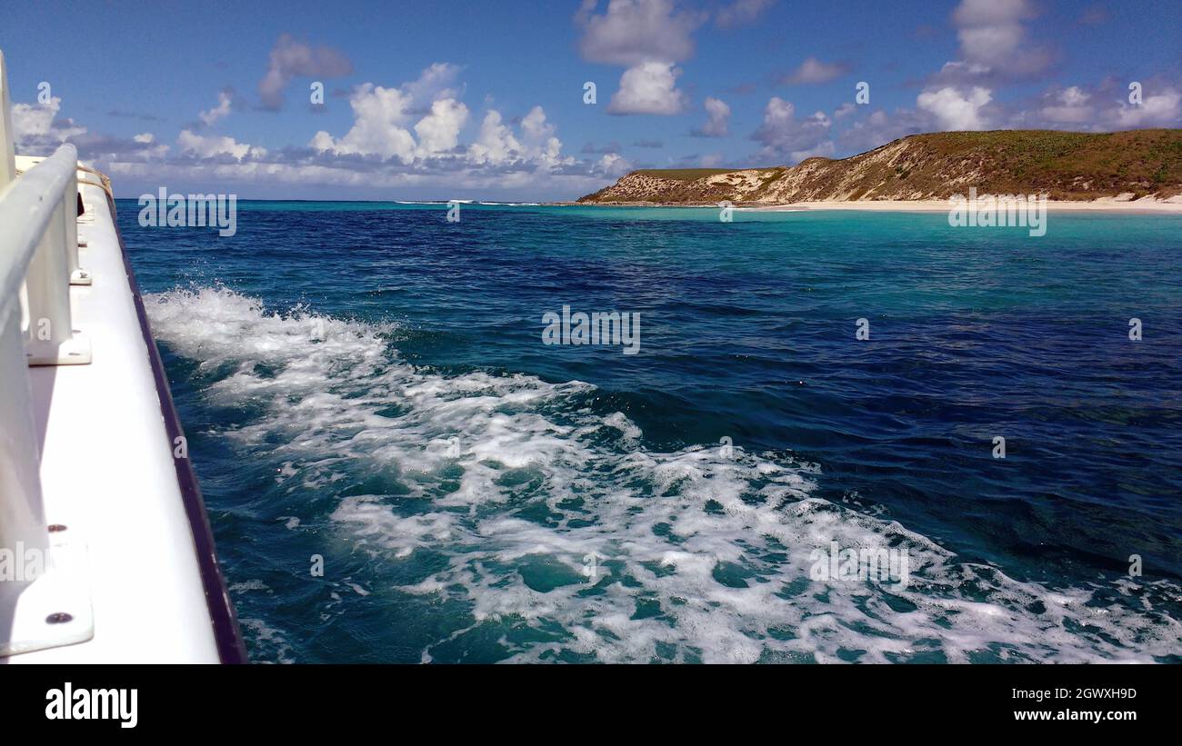 Karibischer Inselstrand und Klippen von einem Motorboot an einem sonnigen Tag Stockfoto
