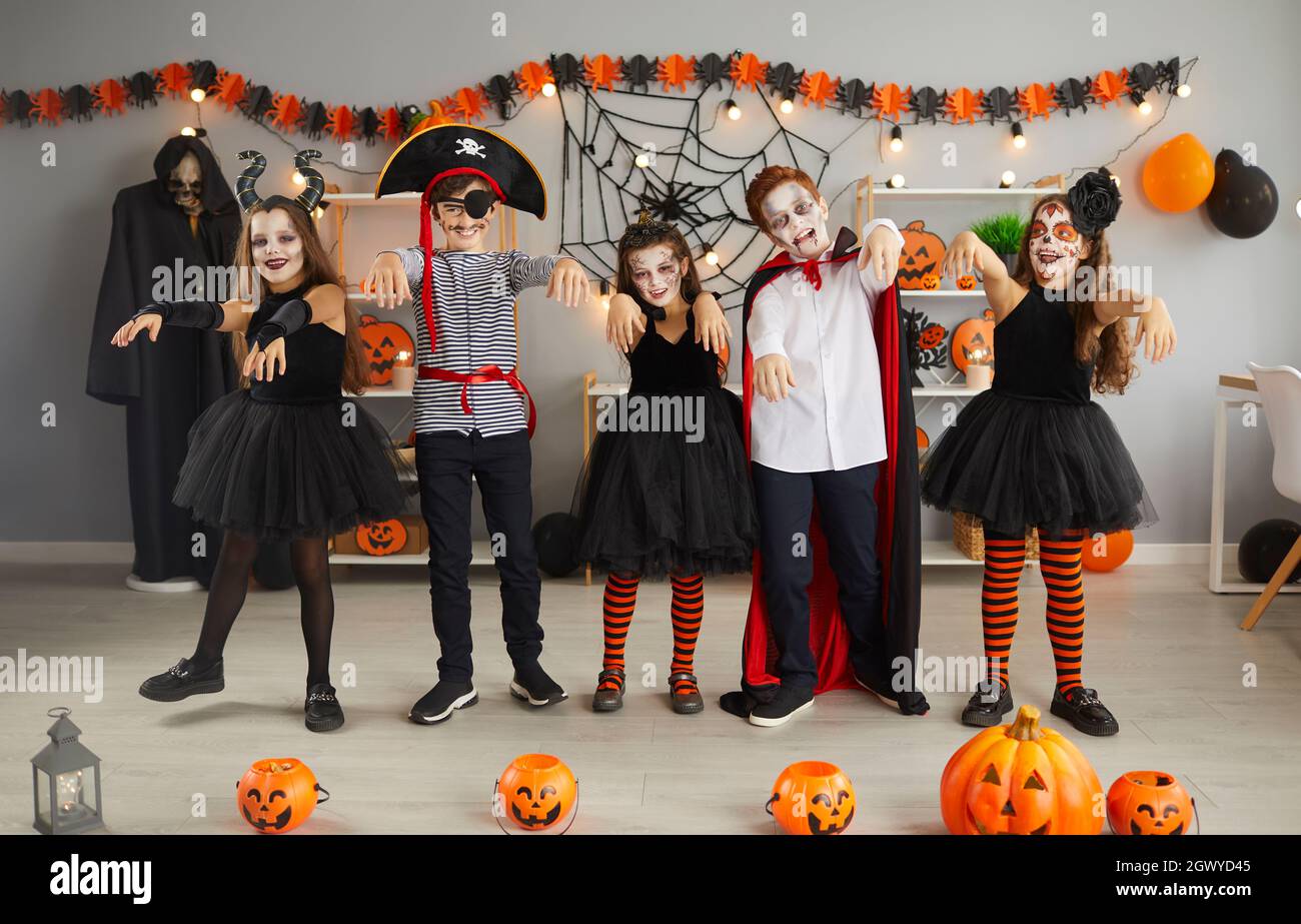 Gruppe von Kindern in gruseligen Kostümen tanzen wie Zombies auf Halloween-Party zu Hause Stockfoto