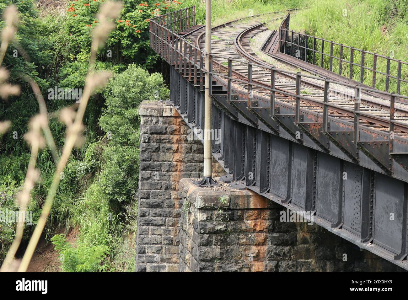 Ein Blick auf die riesige Stahlkonstruktion der schwarzen Brücke liegt auf den Steinblockstützen. Stockfoto