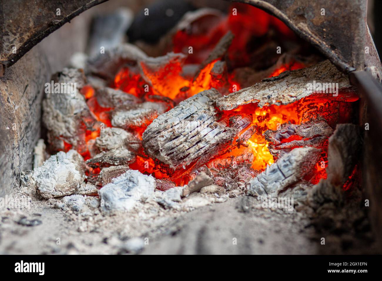 Brennen von Kohlen in einem Metallgrill zum Braten von Fleisch und Gemüse. Kochen am Lagerfeuer. Stockfoto