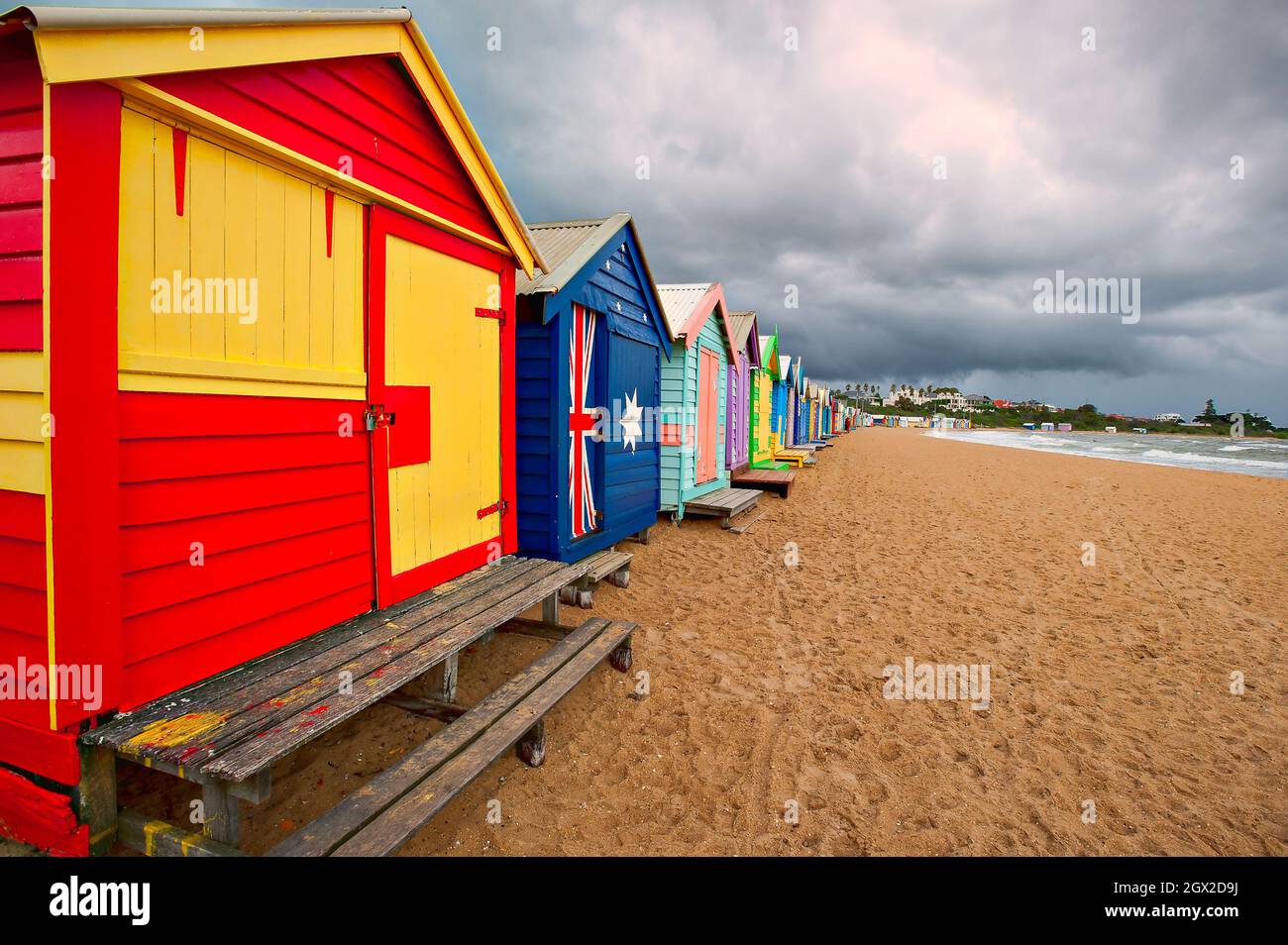 Eine Gewitterfront Ansätze, die bunte, iconic Strand Hütten auf Brighton Beach in der Nähe von Melbourne in Victoria, Australien. Stockfoto