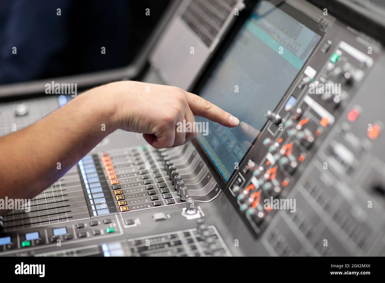 Der Bediener steuert das digitale Audio-Mischpult über einen Touchscreen. Selektiver Fokus. Stockfoto