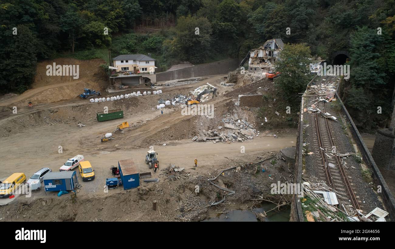 Altenahr, Deutschland. September 2021. Hinter dem Tunnel der Bundesstraße 267 im Ahrtal bei Altenahr reißen Bagger ein Haus ab und bauen gleichzeitig eine provisorische Route, die durch die Flut abgerissen wurde. (Nach dpa: Überflutet beschädigte Rotweinstraße im Ahrtal noch lange unterbrochen). Quelle: Thomas Frey/dpa/Alamy Live News Stockfoto