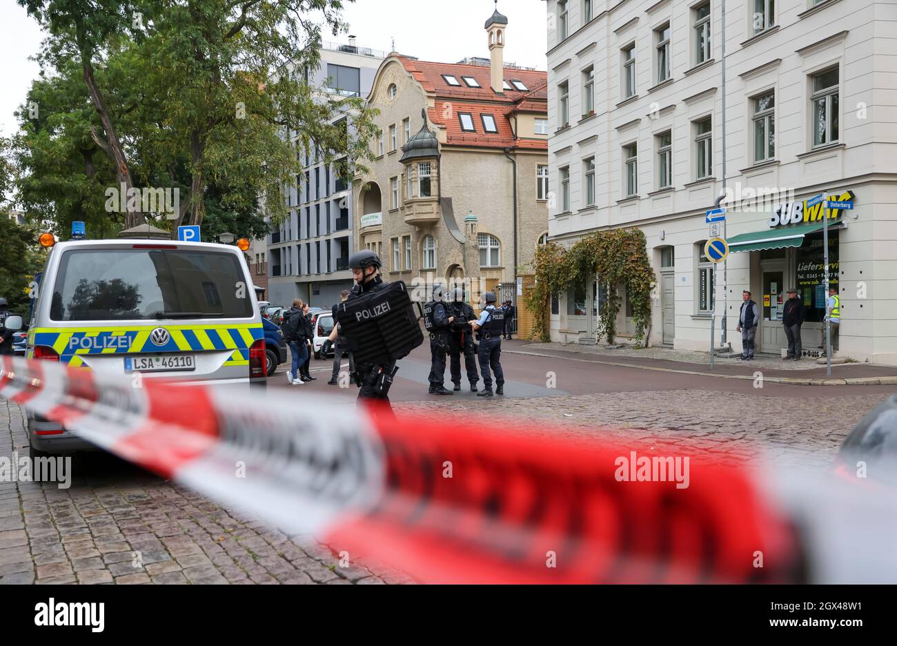 Halle, Deutschland. Oktober 2021. Polizeibeamte stehen vor einer Berufsschule. Das Gebäude wurde nach Androhung von Gewalt evakuiert. Die rund 400 Schüler an zwei Campus der Schule wurden am Montagmorgen nach Hause geschickt, teilte ein Polizeisprecher am Tatort mit. Es gebe keine konkreten Beweise dafür, dass Menschen in unmittelbarer Gefahr seien, sagte er. Quelle: Jan Woitas/dpa-Zentralbild/dpa/Alamy Live News Stockfoto