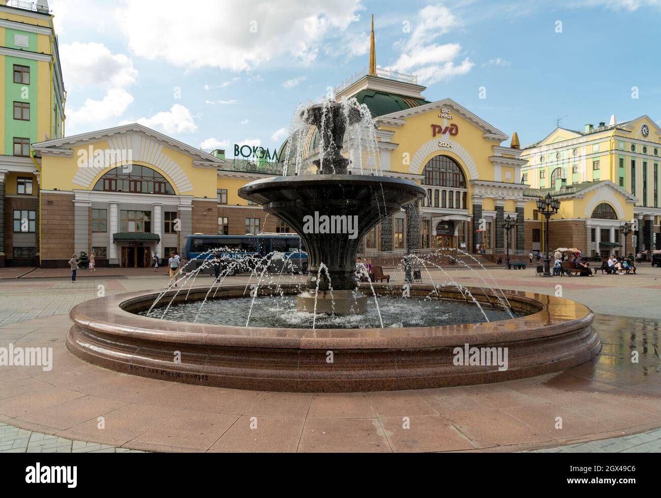 Ein Brunnen auf dem Privokzalnaya-Platz vor dem Hauptbahnhof der Stadt mit dem russischen Eisenbahnlogo auf Russisch an der Fassade. Stockfoto